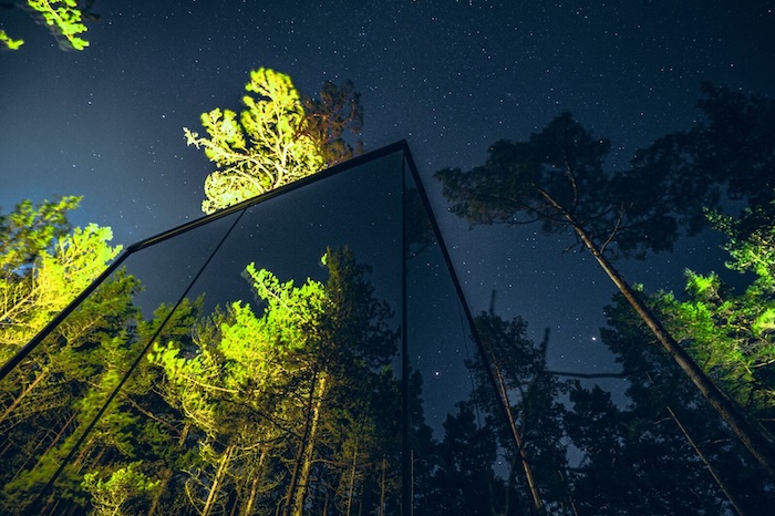 A mirror cabin in a forest at nightfall A mirror cabin in a forest at nightfall