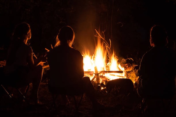 Friends around a campfire at night