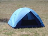 A blue blister tent set up on grass