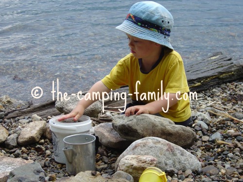 boy playing with rocks and pails