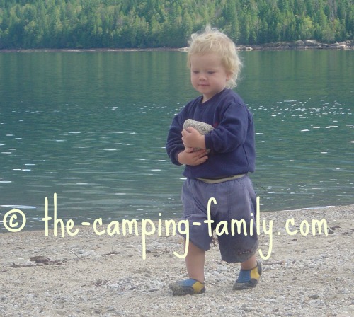 small boy carrying rock