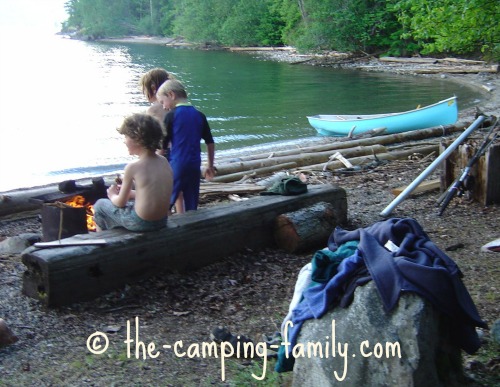 children on beach near canoe