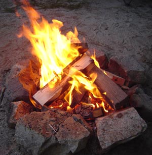 A campfire burning with yellow flames at night A campfire burning with yellow flames at night