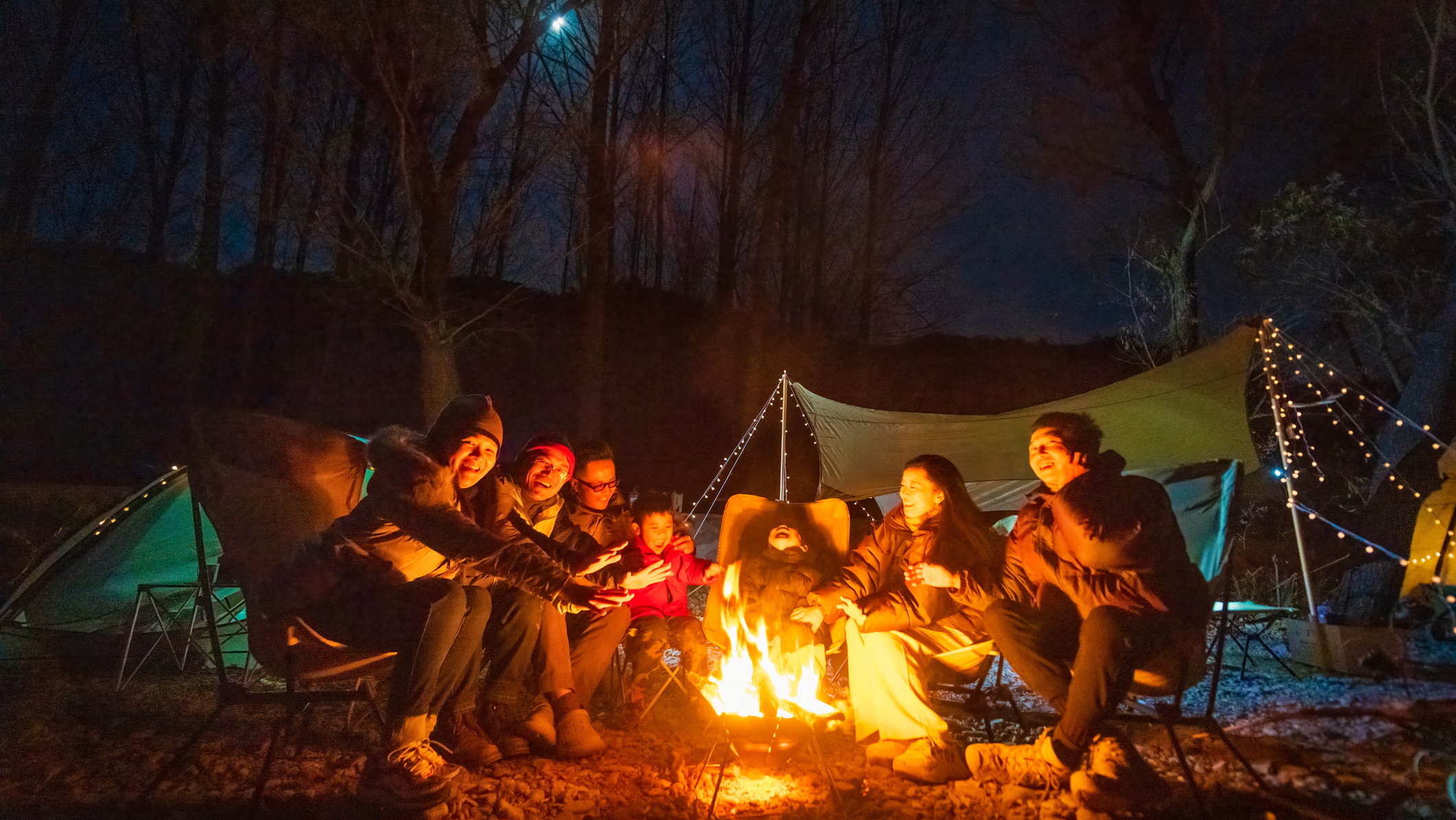 People round a campfire singing