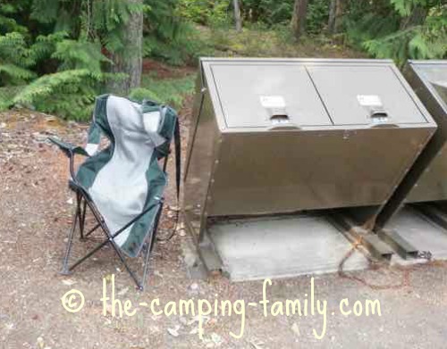 broken camping chair beside dumpster