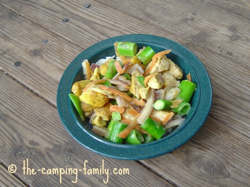 A blue bowl full of healthy food, sitting on a timber surface