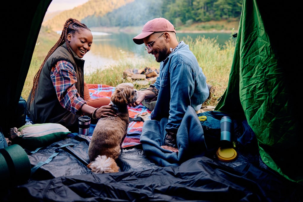 camping couple and dog