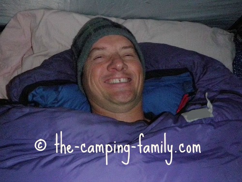 happy guy in warm sleeping bag