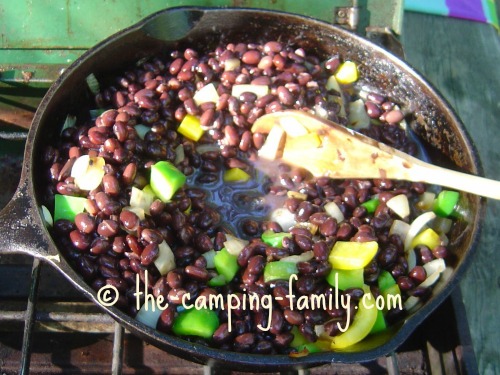 onions, peppers and beans in skillet