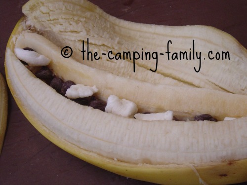 partially peeled banana with chocolate chips and marshmallows