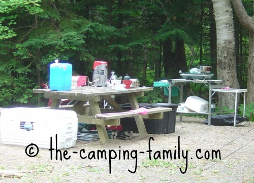 A fixed picnic table and bench seating at a campground