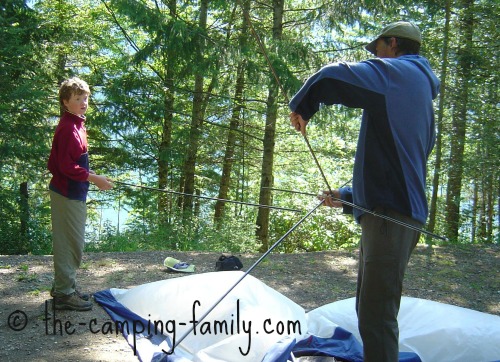 father and son pitching a tent