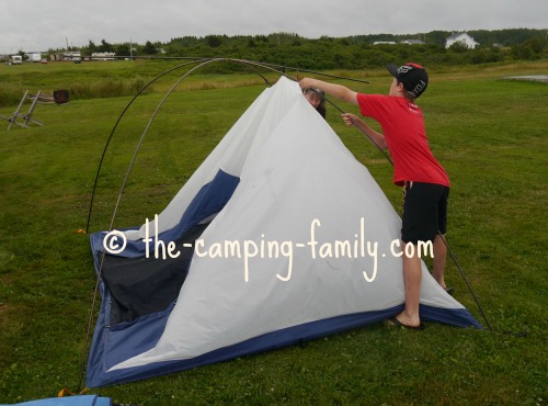 boy setting up a tent