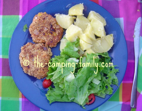 salmon patties on plate with salad and boiled potatoes