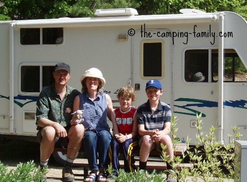 family in front of travel trailer