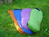 Four sleeping bags laid together on grass