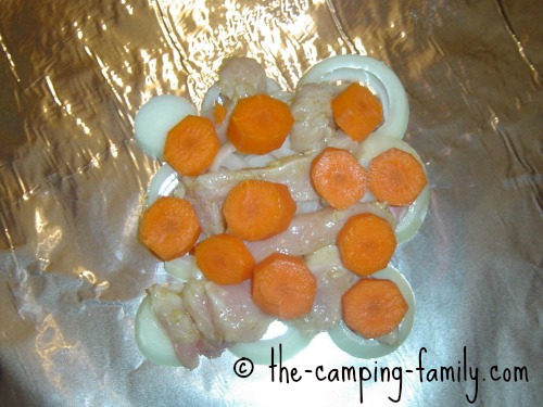 chicken, onions and carrots on foil