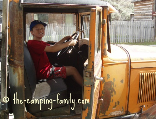 boy in old truck at Bannack State Park