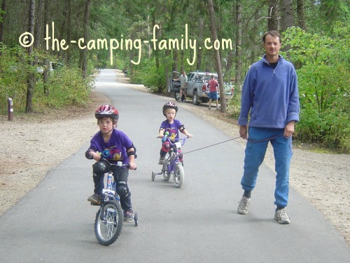 dad and boys biking on paved campground roads