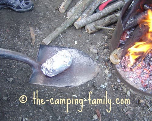 foil wrapped potato on a spade