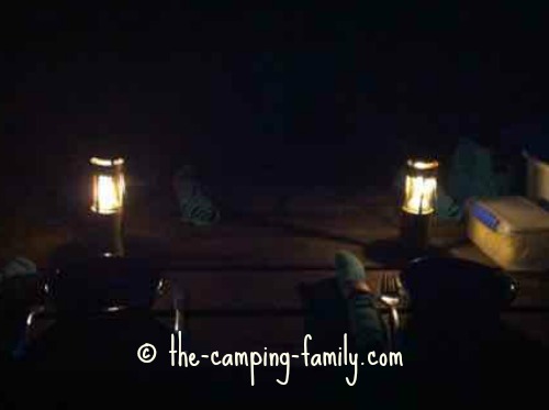 two candle lanterns on picnic table