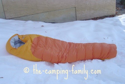 orange down sleeping bag on snow