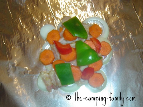 chicken onion carrots and peppers on foil